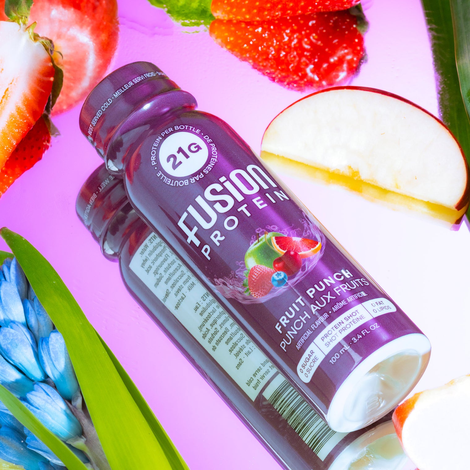 Fusion Protein Fruit Punch shot bottle in water with fresh fruit