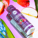 Fusion Protein Fruit Punch shot bottle in water with fresh fruit